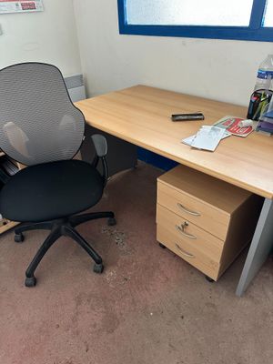 a desk with a chair and a file cabinet in the corner