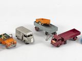 plusieurs camions jouets sont alignés sur une surface blanche