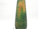 un vase vert et jaune sur lequel sont peints des arbres