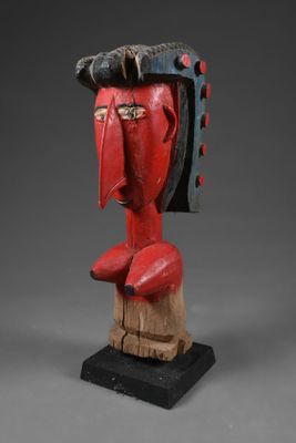 une sculpture en bois représentant le visage d'un homme coiffé d'un chapeau