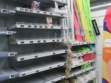 many empty shelves in a store that are full of supplies