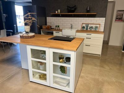 une cuisine avec un plan de travail en bois et des placards blancs