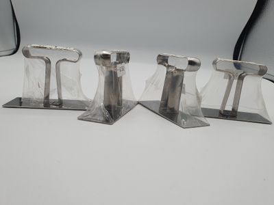 trois pièces métalliques argentées sur une surface blanche