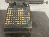 an old typewriter sitting on top of a table next to a brick wall
