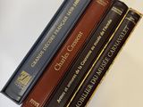 trois livres sont empilés sur une table
