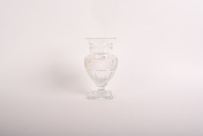 un vase en verre transparent posé sur une surface blanche