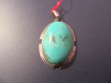 une photo d'un pendentif orné d'une pierre turquoise