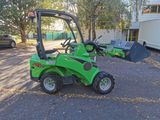 a small green tractor that is parked in the parking lot