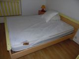 un lit recouvert d'un drap blanc dans une petite chambre