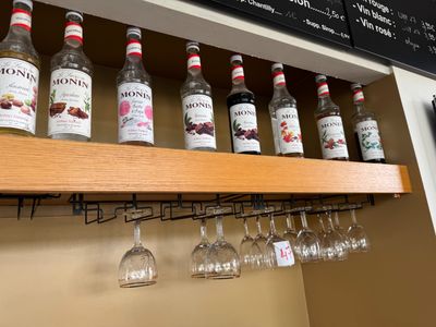 de nombreuses bouteilles et verres sur l'étagère au-dessus des verres à vin