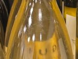 plusieurs bouteilles de vin posées sur une étagère, avec leurs étiquettes