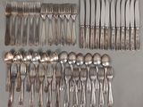de nombreuses fourchettes et cuillères disposées sur la table
