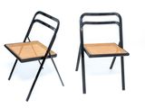 pair of black metal folding chairs with wicker seat and back