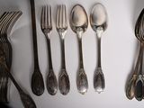a lot of silver spoons and forks on the table