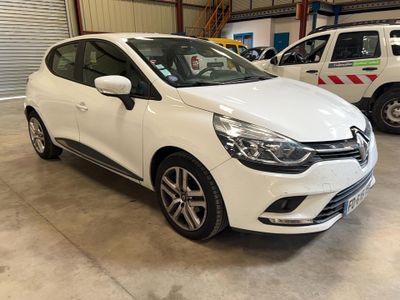 une voiture blanche garée dans un garage à côté d'autres voitures