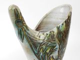 a close up of a vase with a bird on it