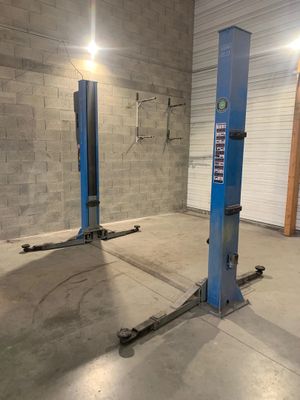 a garage with two blue lifts in the middle of it