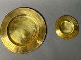 two gold plates that are sitting on a table