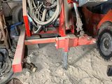 an image of a red tractor with a hose attached to it