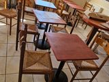 tables and chairs are lined up in a restaurant with a large window
