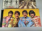 three beatles album covers on a table with a picture of the beatles