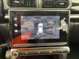 someone is taking a picture of a car with a cell phone in their hand