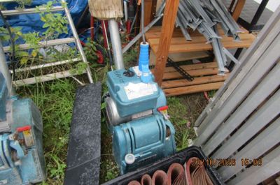 une machine bleue posée à côté d'un tas de ferraille