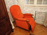 une chaise orange posée dans un coin d'une pièce