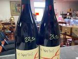two bottles of wine sitting on a counter in a restaurant