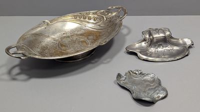 three silver objects are sitting on a table next to each other