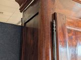 a large wooden cabinet with a door on top of it