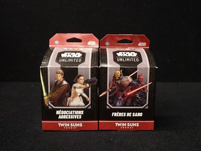 Deux boîtes de figurines Star Wars sont posées sur une surface noire