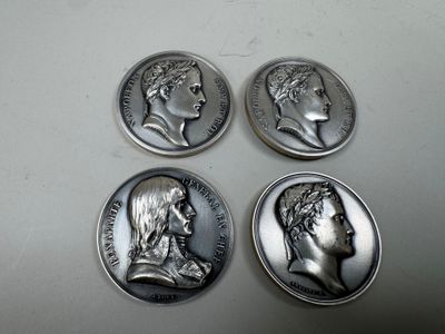 four silver coins with heads of men on them sitting on a table