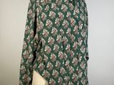 a green and white floral shirt on a mannequin mannequin