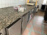 a kitchen with a counter, oven, and refrigerator in it
