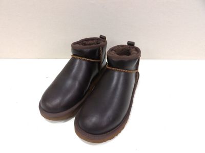 the children ' s black boots are lined up on a white surface