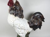 a figurine of a rooster on a green base