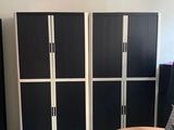 plusieurs casiers noirs et blancs dans une pièce équipée d'une table et d'une chaise