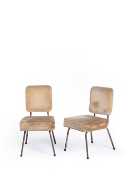 two wooden chairs sitting next to each other on a white surface