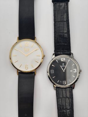 deux montres noires et blanches posées l'une à côté de l'autre sur une surface blanche