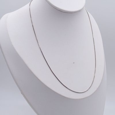 a close up of a necklace on a mannequin with a white background