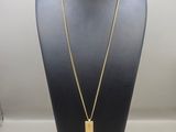 a gold necklace with a long tassel hanging from it ' s neck