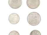 six different types of silver coins on a white surface