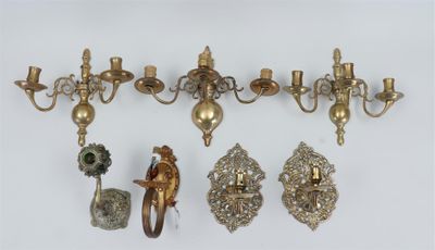 several antique brass wall sconces and a pair of candle holders