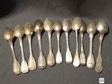 six silver spoons are lined up in a row on a table