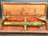 une vieille pipe en laiton dans une boîte en bois posée sur une table