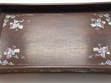 un plateau marron orné de fleurs, posé sur une table