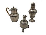 deux vases en argent et une théière placés les uns à côté des autres