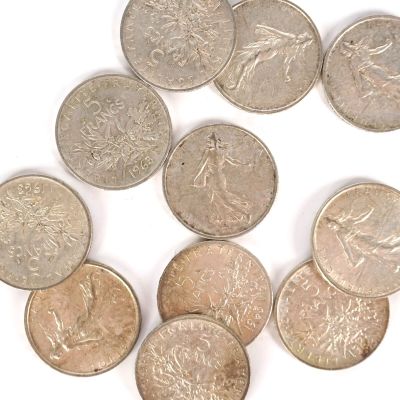 plusieurs pièces de monnaie sont disposées en cercle sur une surface blanche