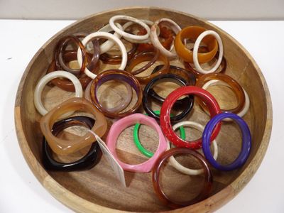 a wooden bowl filled with lots of different colored rings